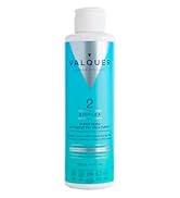 Le texte indique « VALQUER ». Flacon pulvérisateur aérosol bleu clair avec bouchon blanc, orné d'un logo minimaliste en triangle argenté.