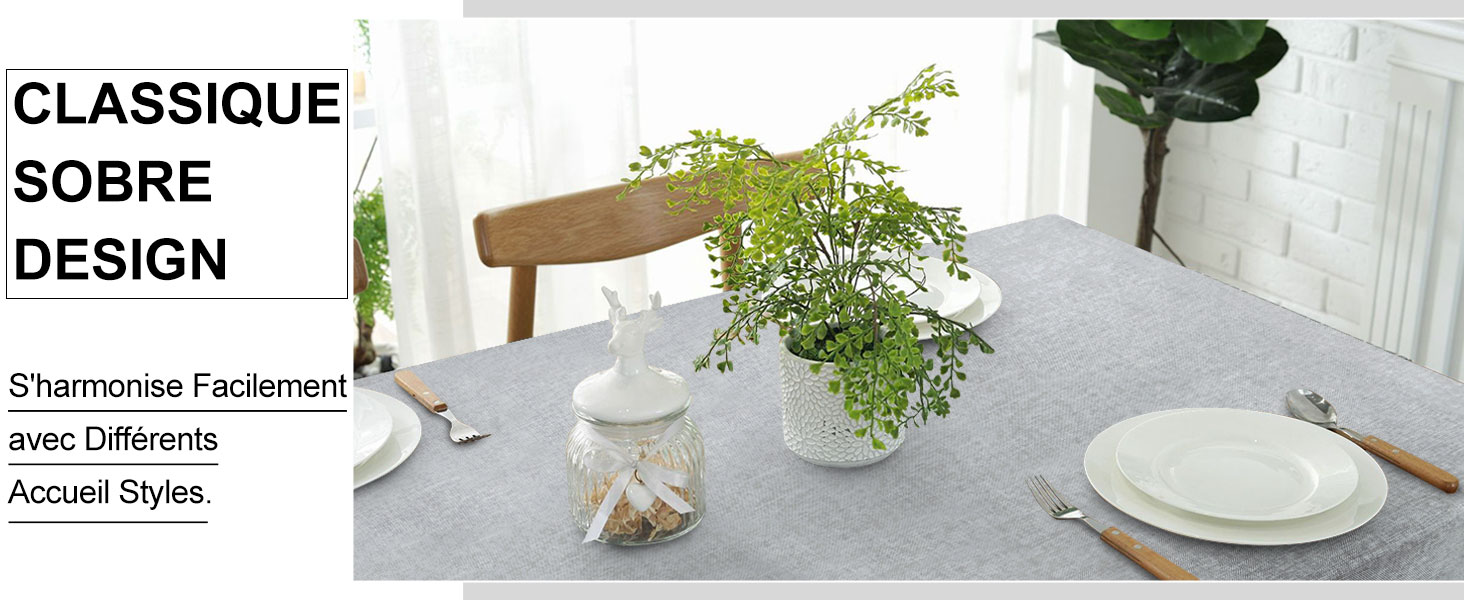 Ensemble de table à manger moderne avec une nappe grise, des assiettes blanches, des fougères en pot et des chaises en bois minimalistes dans
