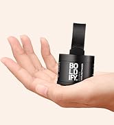Petit produit cylindrique noir étiqueté « BOLDIFY » tenu dans une paume ouverte, ce qui suggère sa taille compacte. Le produit possède un bouchon en forme de distributeur.